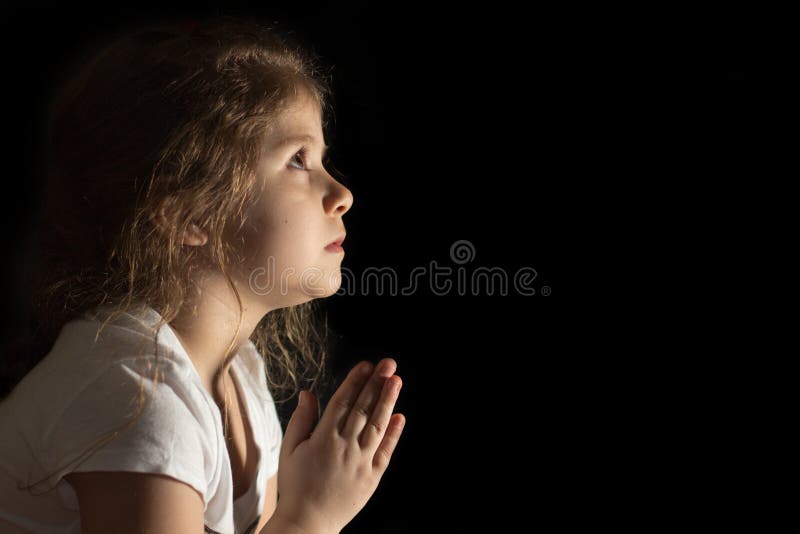 Little girl praying to God divine light put your hands in prayer