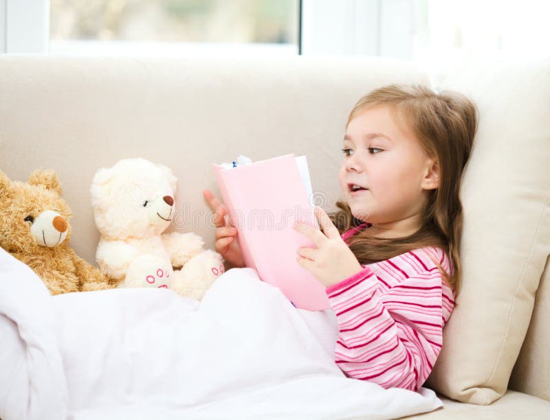 Little girl is reading a book for her teddy bears royalty free stock photo Little girl is reading a book for her teddy bears royalty free stock photo