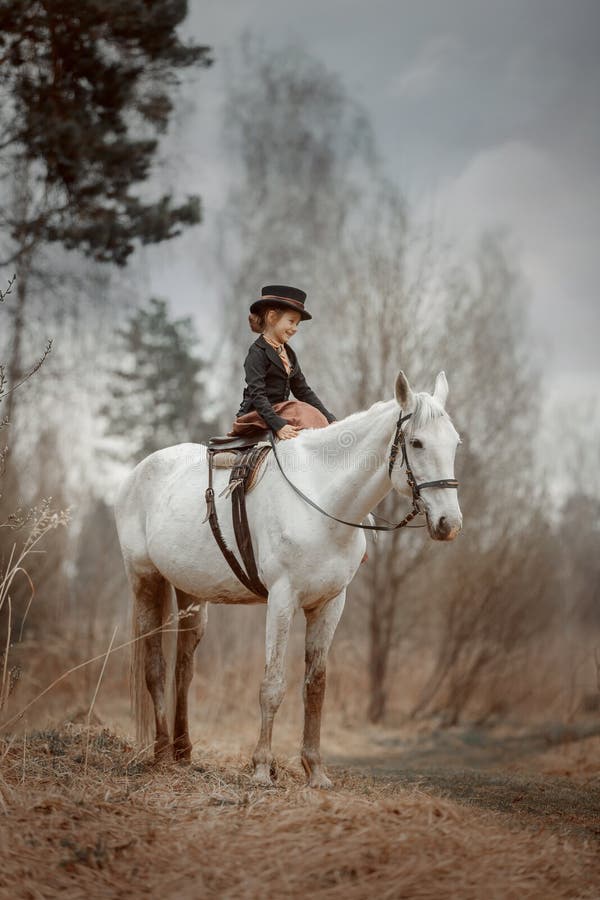 Little girl in riding habit with horse and vizsla