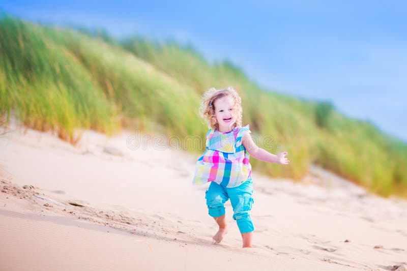 Little girl runnign in sand dunes