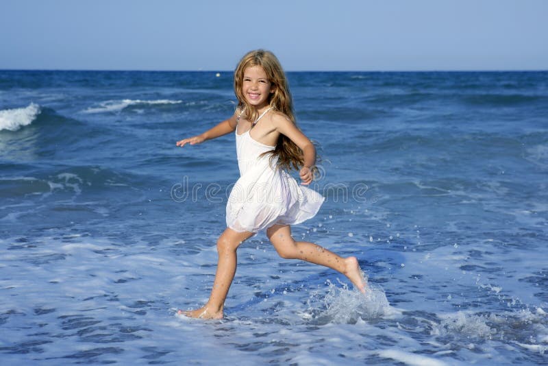 Little girl running beach in blue sea