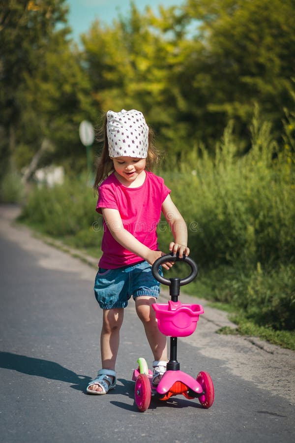 Little girl on scooter stock image. Image of leisure 76448817