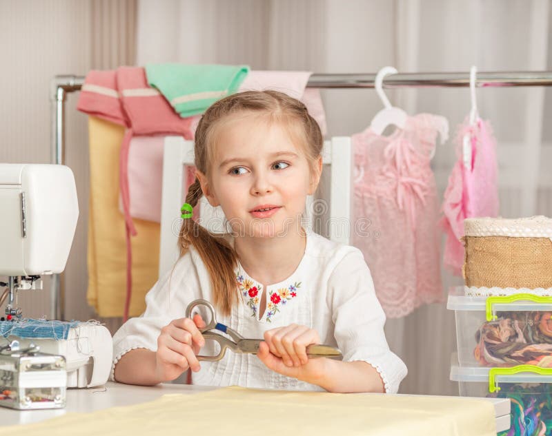 Little girl in a sewing workshop stock image