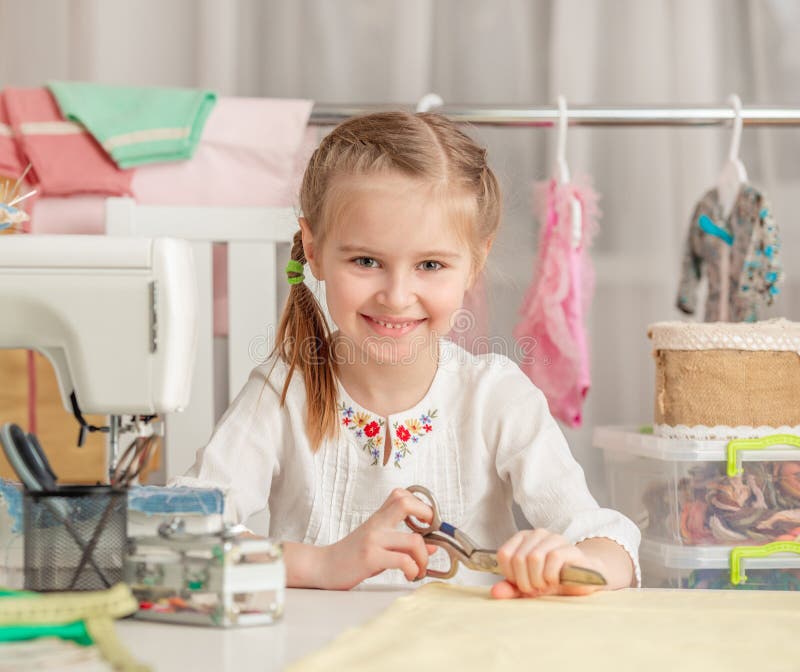 Little girl in a sewing workshop royalty free stock photo