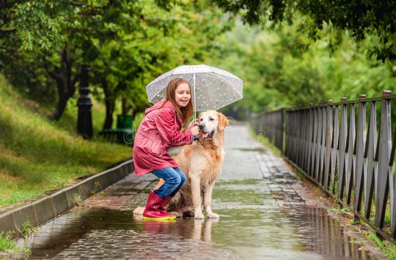 Little girl sharing umbrella with dog