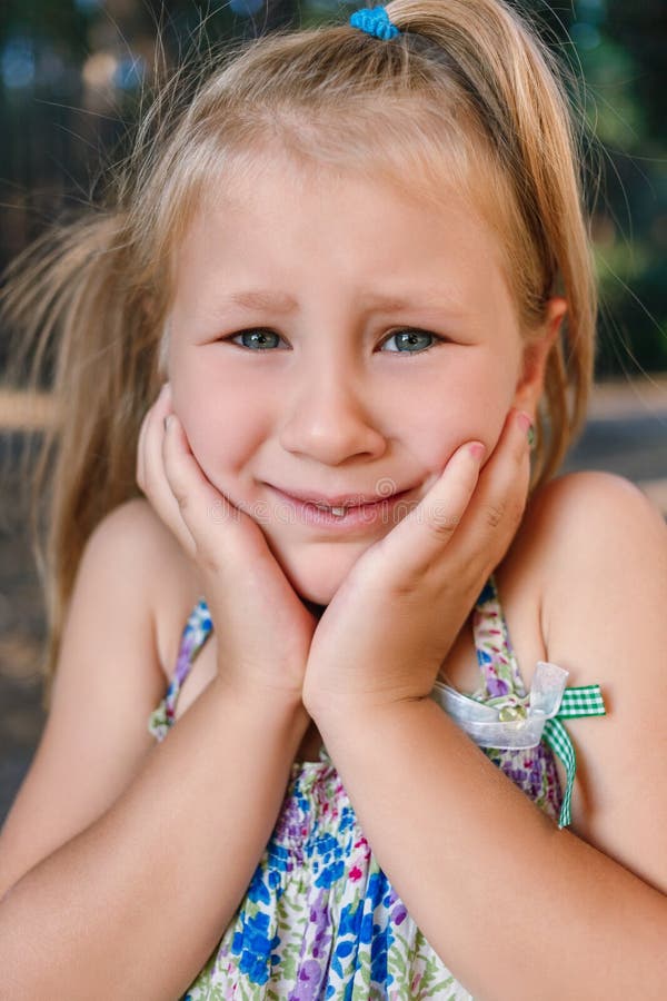 A little girl shows a wobbly baby tooth in her mouth