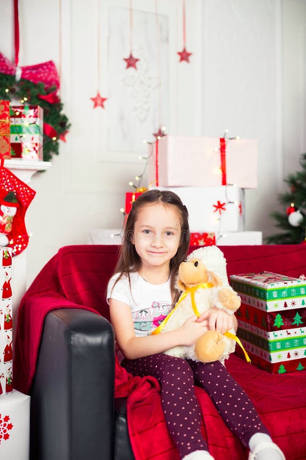 Little Girl Sitting on Coach Holding Stuffed Toy Stock Photo - Image of ...