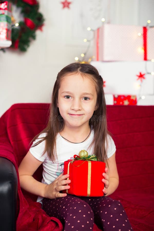 Little Girl Sitting on Couch Holding Red Box, Gift Stock Photo - Image ...