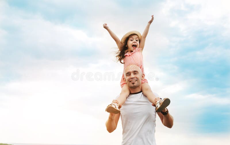 Little girl sitting on father`s shoulders