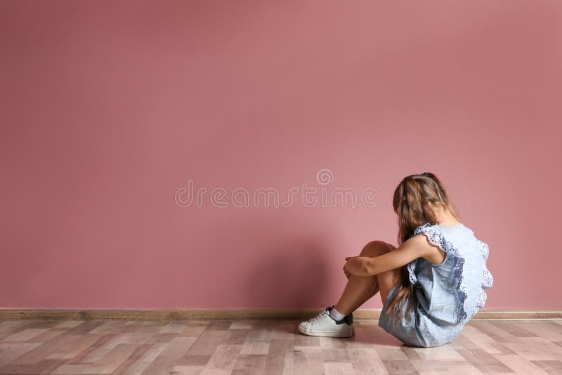 Little girl sitting on floor near color wall in empty room royalty free stock images Little girl sitting on floor near color wall in empty room royalty free stock images