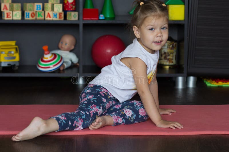 Little Girl Sitting on Mat Indoor before Physical Training Stock Image