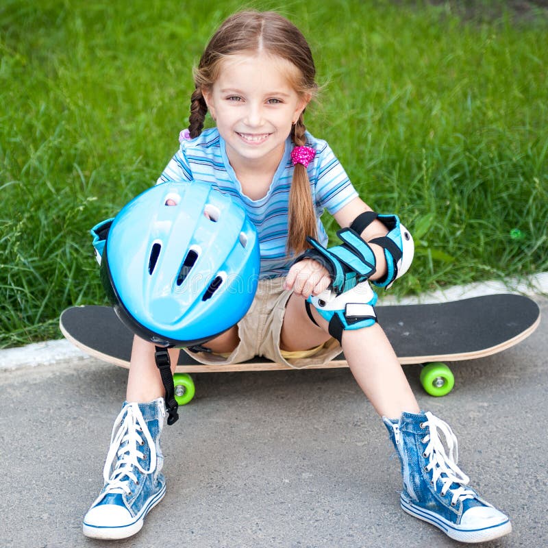 Little girl sitting on a skateboard