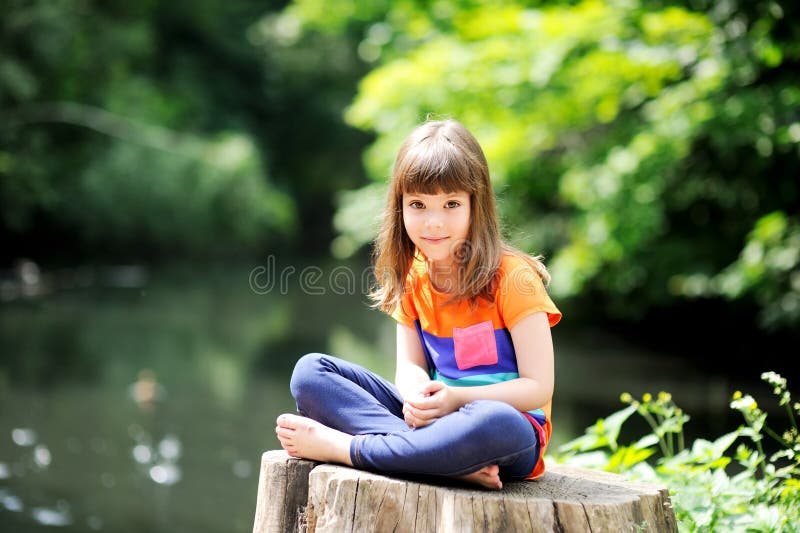 Little girl sitting on stump