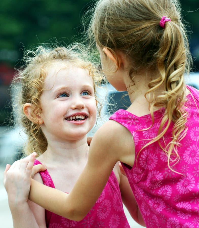 A Little Girl Smiles Adoringly at Her Sister