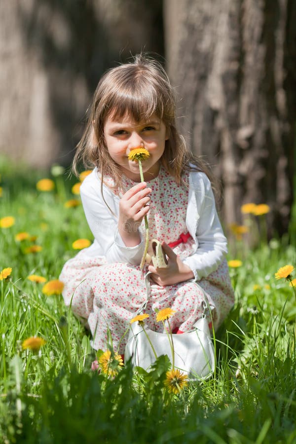 Little girl sniffing flower