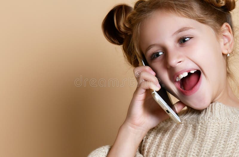 Little girl speaking by cell phone, nude background royalty free stock photography Little girl speaking by cell phone, nude background royalty free stock photography