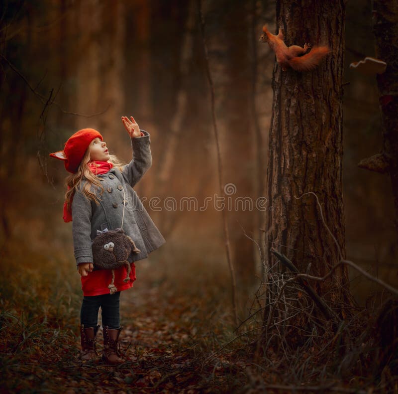 Little girl with squirrel  in an autumn forest