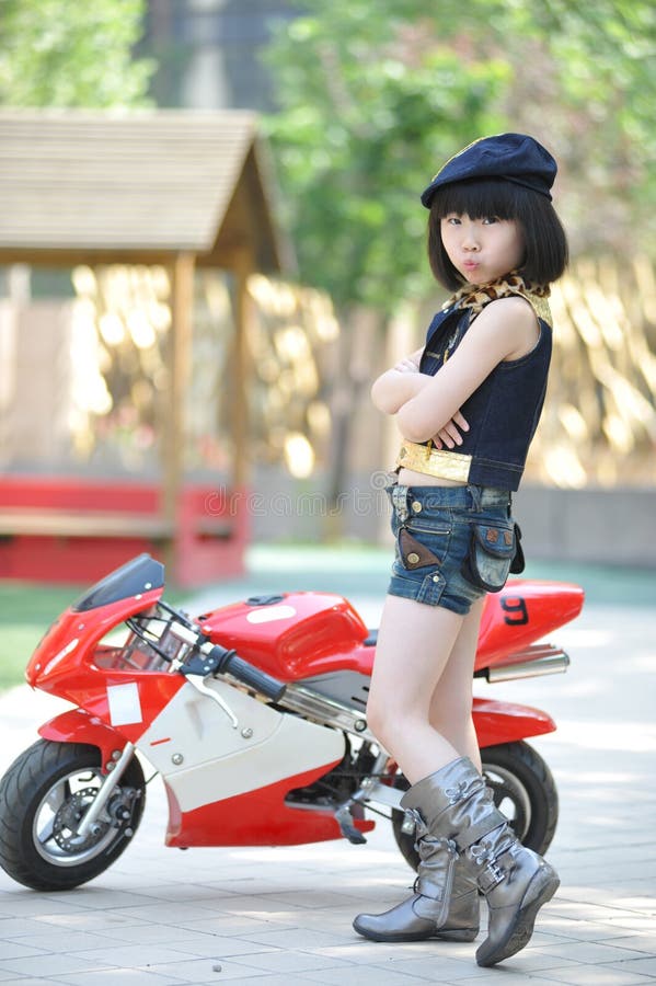 Little girl standing by the motorcycle