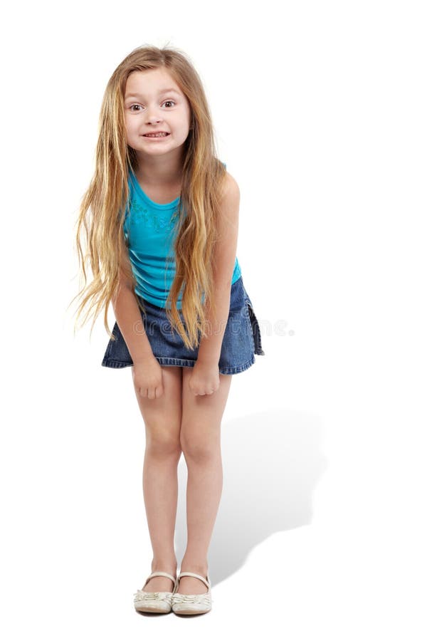 Little girl stands slightly bending forward