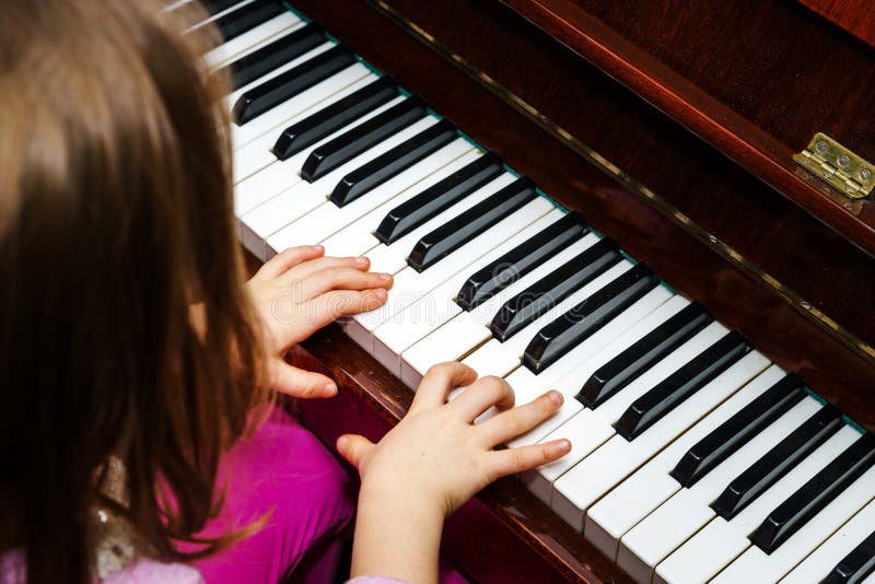Little girl studing to play the piano royalty free stock photo