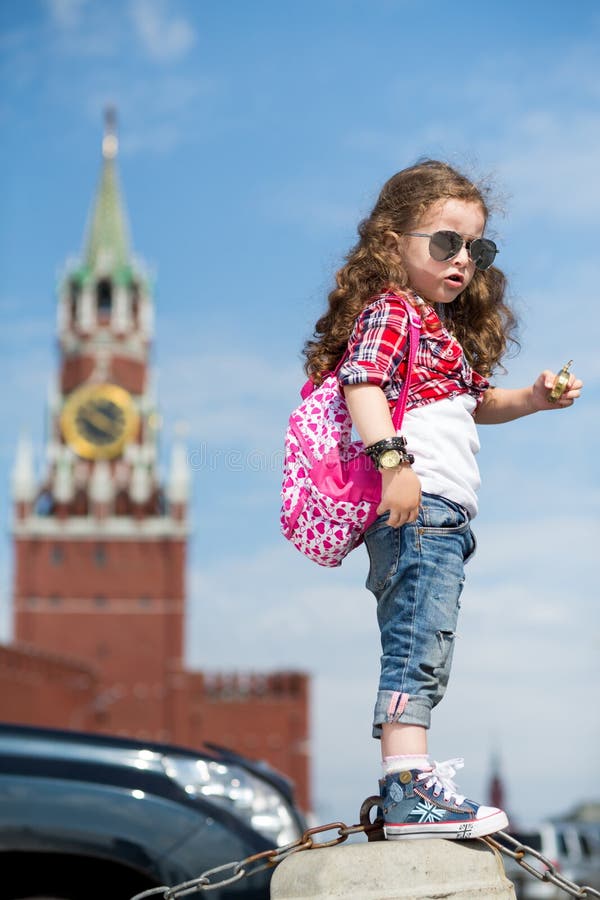 The little girl in stylish dress and sunglasses near the Kremlin royalty free stock image The little girl in stylish dress and sunglasses near the Kremlin royalty free stock image
