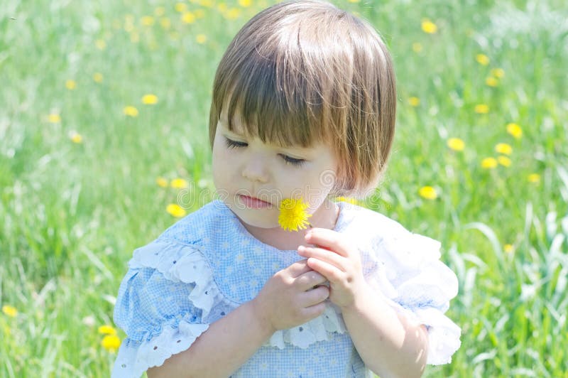 Little girl in summer with dandelion flower