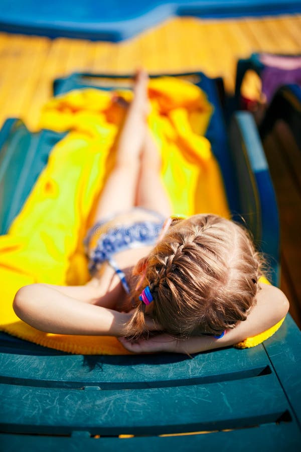 Little Girl Sunbathing At The Beach Stock Photo - Download 