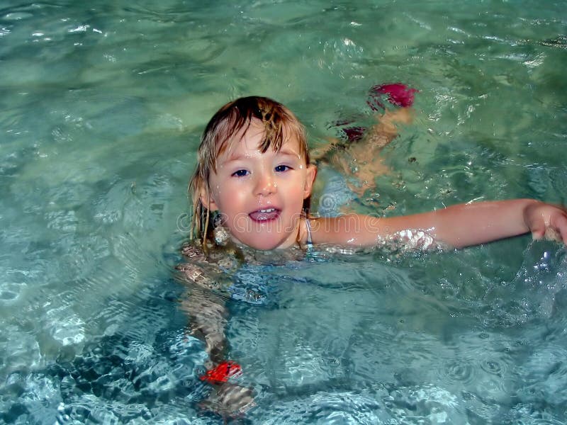 Una ragazza carina di nuoto e tuffi in piscina.