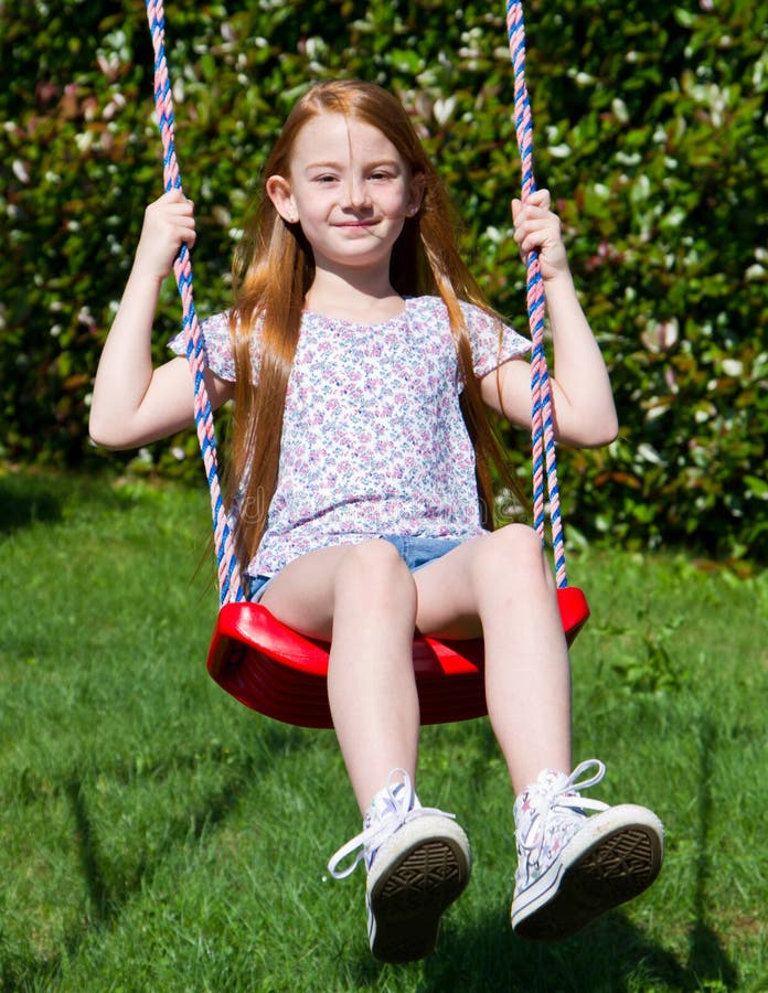The little girl on the swing stock photo