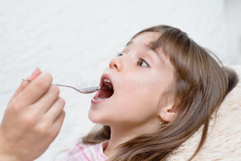 Little girl taking medicine with spoon stock photo Little girl taking medicine with spoon stock photo