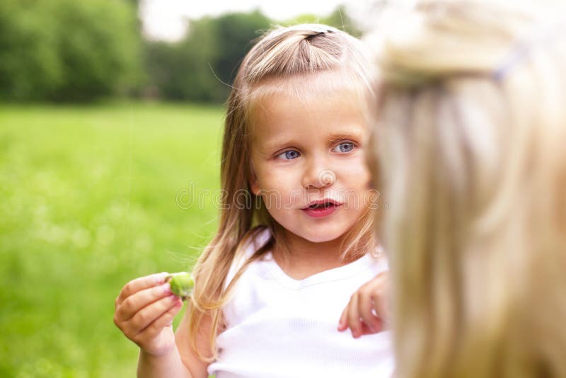 A little girl is talking with her mother