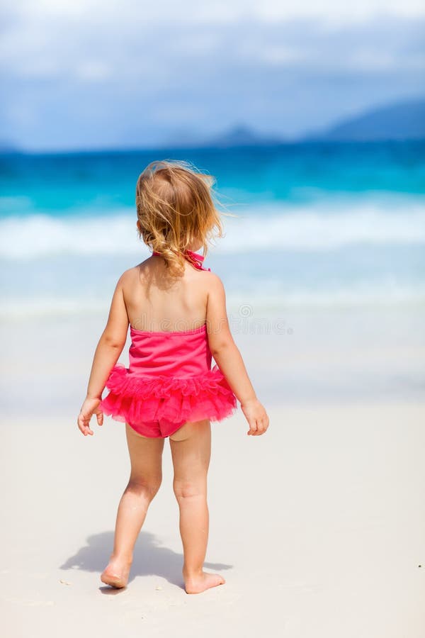 Premium Photo  Little brunette girl wearing a swimsuit on the beach from  the back facing the ocean with the sky in the background concept of beach  vacation sun protection sea lifestyle