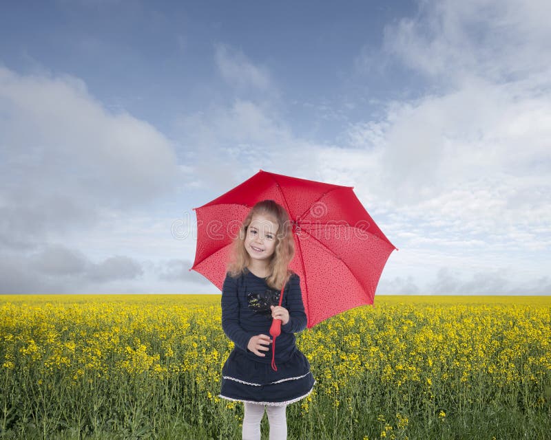 Little girl with umbrella in front of an oilseed field royalty free stock photo Little girl with umbrella in front of an oilseed field royalty free stock photo