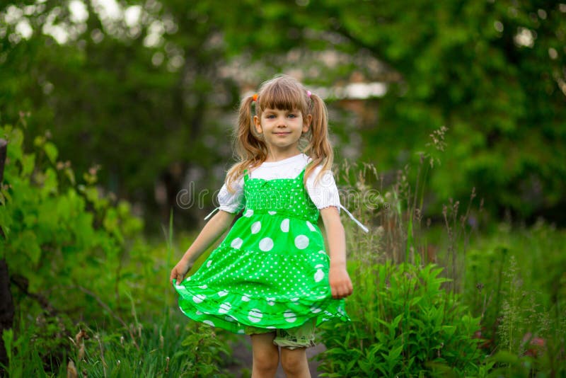 Little girl walk in green garden