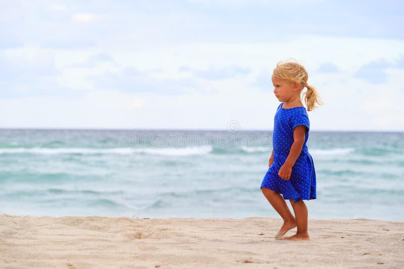 Little girl walk on sand beach