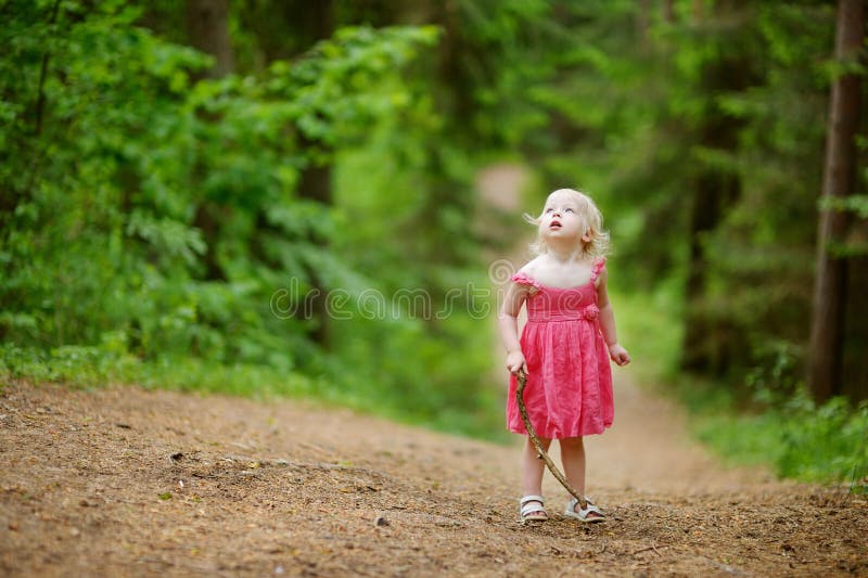 Little girl wearing pink dress walking all alone