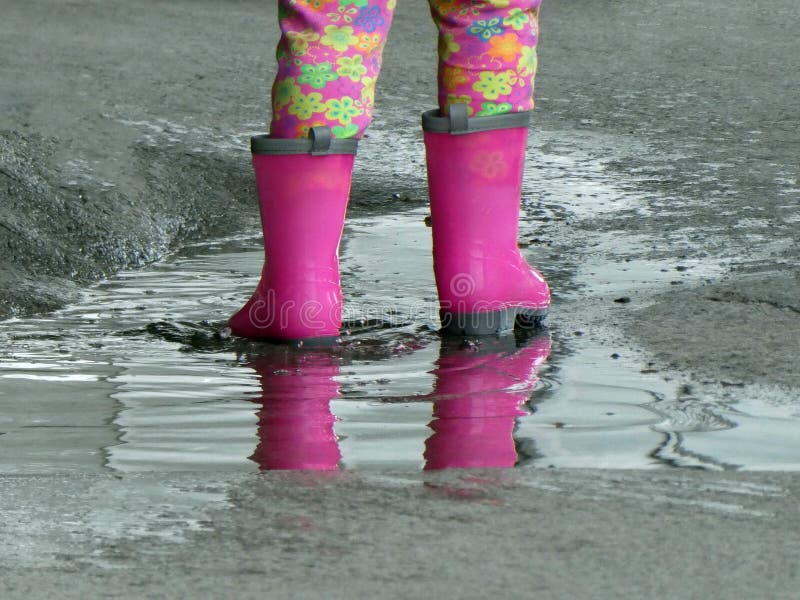 Little Girl in Pink Rain Boots Standing in a Puddle after Rain with ...