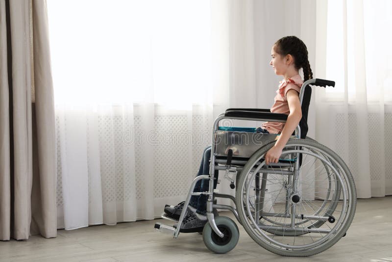 Little girl in wheelchair near window indoors stock images Little girl in wheelchair near window indoors stock images