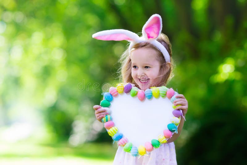 Little girl with white board for Easter greetings royalty free stock images Little girl with white board for Easter greetings royalty free stock images