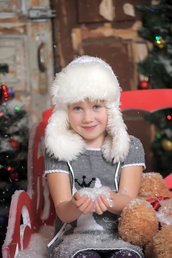 Little Girl in a White Fur Hat and Snow in the Hands Stock Photo ...