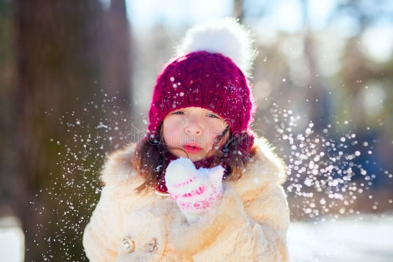 Preschool kid boy in colorful clothes playing outdoors during strong  snowfall. Active leisure with children in winter on cold snowy days. Happy  child having fun, playing with snow. Winter fashion. Stock Photo