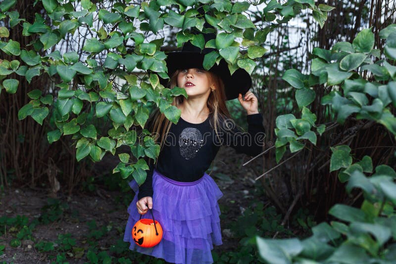 Little Girl in Witch Costume on Halloween Trick or Treat in Garden ...