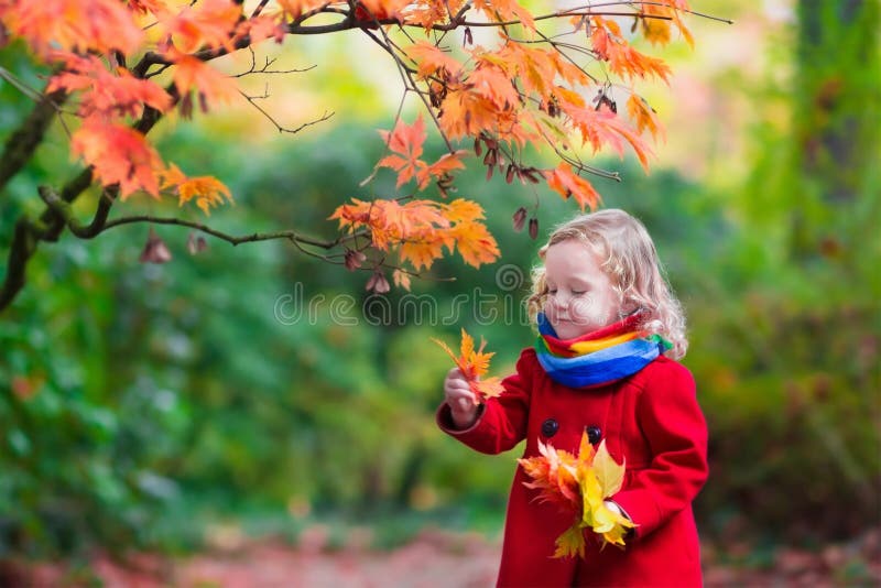 Little girl with yellow autumn leaf