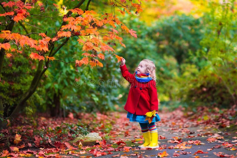 Little girl with yellow autumn leaf