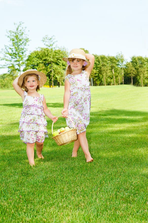 Little girls carrying fruit basket stock images