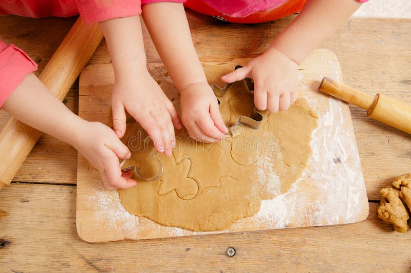 Little girls cutting gingerbread christmas cookies