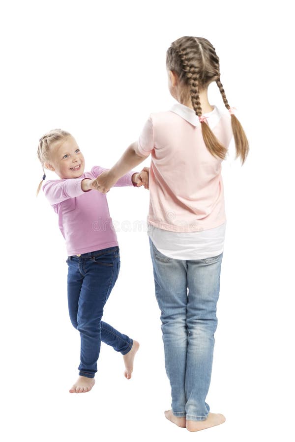 Little girls girlfriends in jeans and pink sweaters hold hands and laugh. Tenderness and friendship. Isolated over white stock photo Little girls girlfriends in jeans and pink sweaters hold hands and laugh. Tenderness and friendship. Isolated over white stock photo