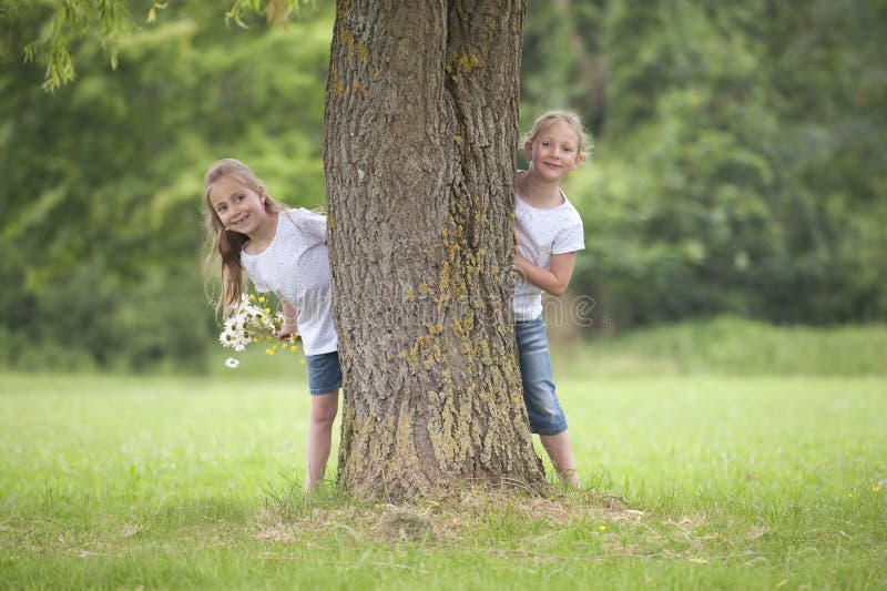 Little girls playing hide and seek in the park