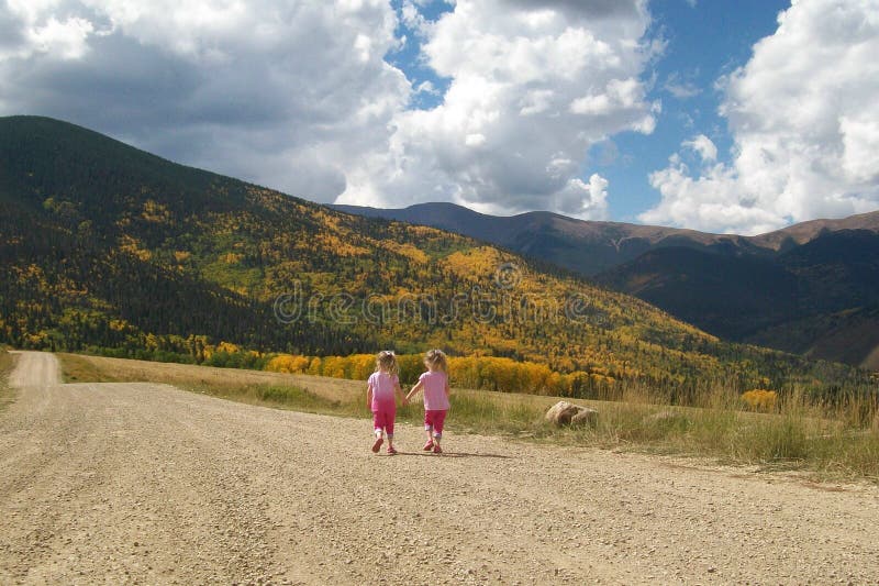 Little Girls Twin Sisters Friends Walking Hand in Hand. royalty free stock photo Little Girls Twin Sisters Friends Walking Hand in Hand. royalty free stock photo