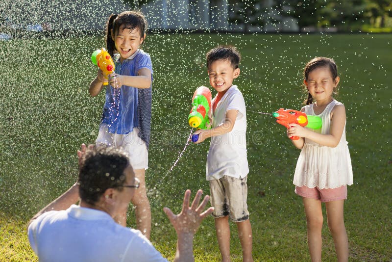 Little guys using water guns to spray their father